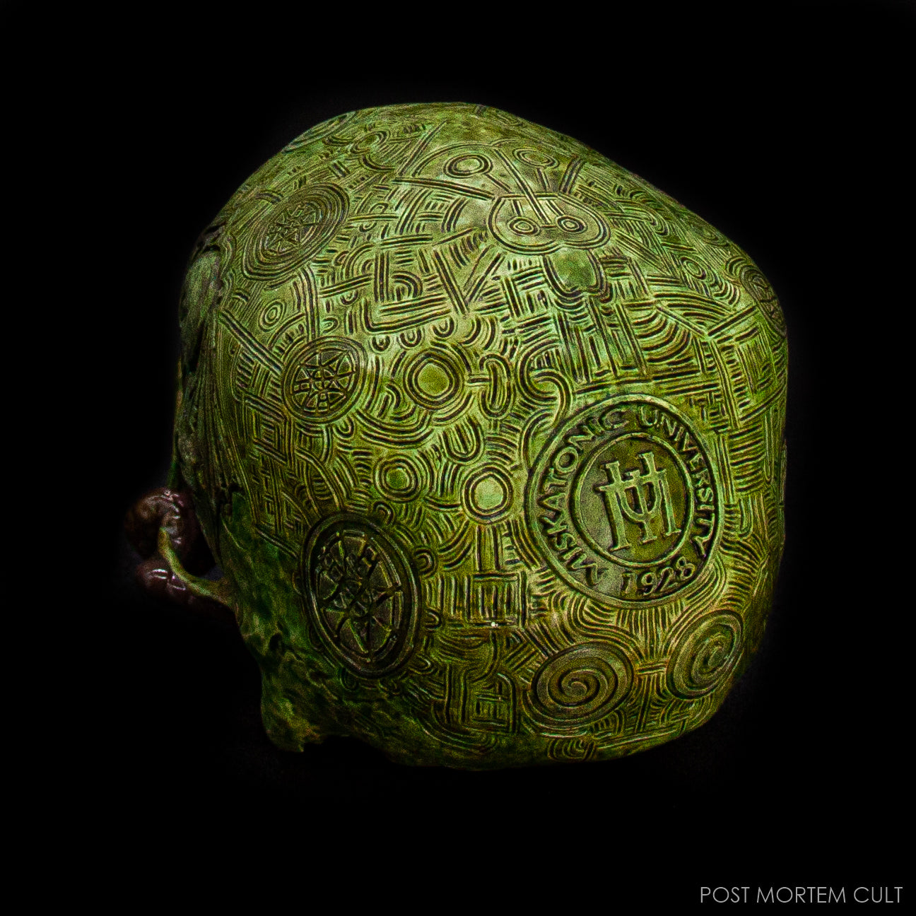 Dark-lit photo showing the glowing runes of the H. P. Lovecraft Skull sculpture.