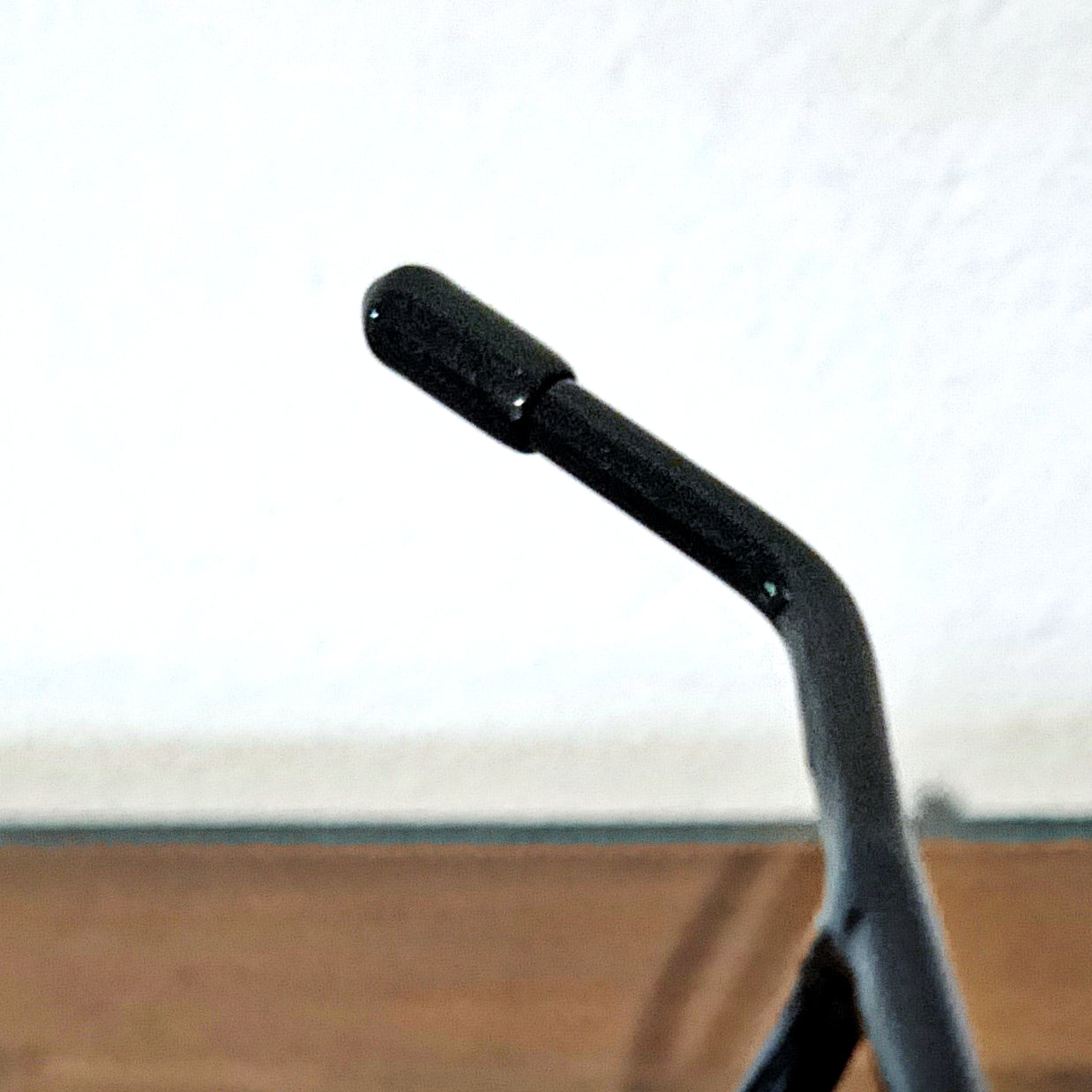 Close-up view of the glossy black metal arms of this skull stand, showing precision craftsmanship and a professional display finish.