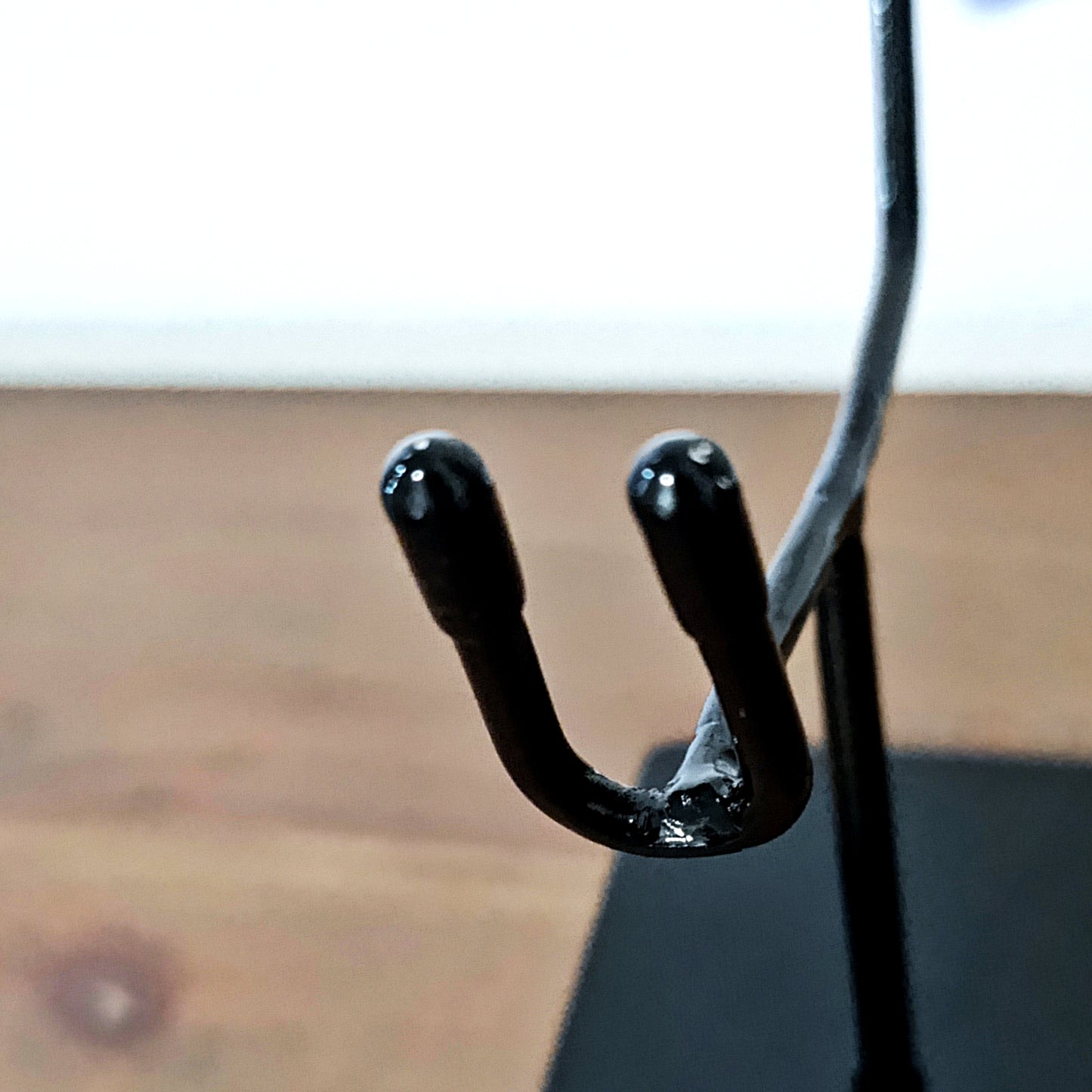 Sturdy metal skull display with sleek black gloss surface, providing both stability and a clean modern look for exhibition and photography.